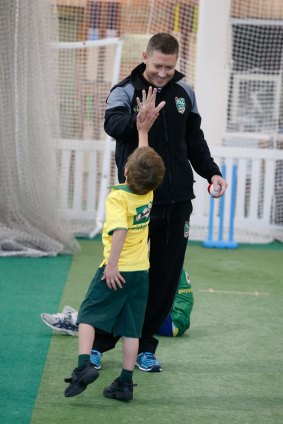 High five: Michael Clarke celebrates at the clinic.