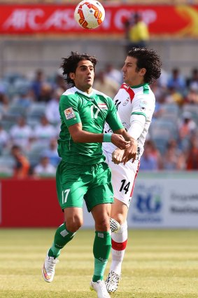 Controversy: Alaa Abdulzehra, left, and Iran's Andranik Teymourian clash during Friday's Asian Cup quarter-final.