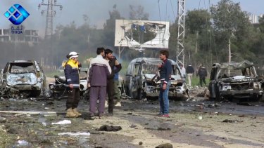 Rebel gunmen at the site of a blast that damaged several buses and vans.