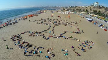 On Agua Dulce beach in Lima, native Peruvian activists formed an indigenous symbol and the words 'People and rights. Alive woods' to call attention to climate change.