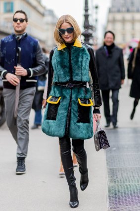 Olivia Palermo wearing a fur coat and black leather pants and Dior bag outside Dior during the Paris Fashion Week.