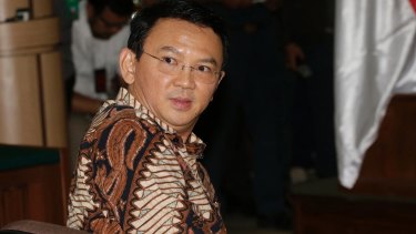 Jakarta governor Ahok sits on the defendant's chair at the start of his trial.
