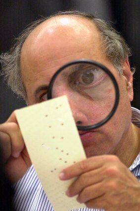 Judge Robert Rosenberg uses a magnifying glass to examine a disputed ballot paper during the Florida recount of 2000. 