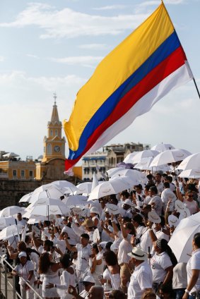 People wait for the start of the peace ceremony in Cartagena, Colombia on Monday.