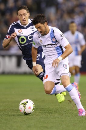 City's star player David Villa is tracked by Victory's skipper Mark Milligan.