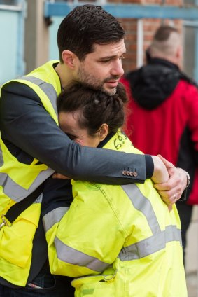 People comfort one another outside Brussels airport.