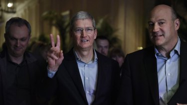 Apple CEO Tim Cook, centre, arrives to speak with Gary Cohn, president and COO of Goldman Sachs, right, at the event where he announced the tech giant's latest investment in solar power.