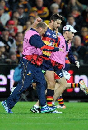 Taylor Walker of the Crows comes off with an injury.