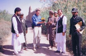 Making a difference: Ian Mansfield, third from left, is presented with a bunch of flowers by an Afghan man near Kandahar in the early 1990s. The man was grateful for the work done to demine his land. "It is one of the best gifts I have ever received," Mansfield said.