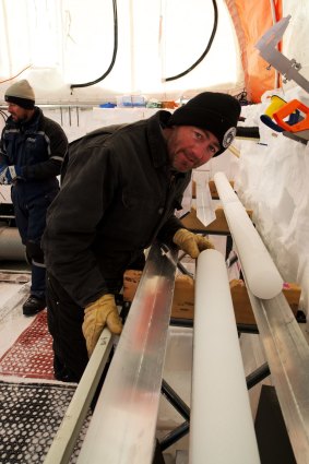 Dr Mark Curran examines an ice core inside the tent at the Aurora Basin North campsite.