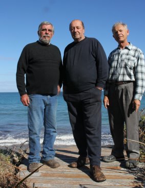 Mr Thomas with fellow residents Mac Formica and Jim Batalin on a walkway that used to lead to the beach but whose edge now hangs in midair inches behind where they stand.