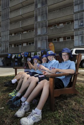 Breaking down barriers: At the Currong Apartments, Braddon, Ainslie School students test out a timber garden bench, made by Ainslie Avenue residents and
donated to the school to be raffled. Students from left Asha Moore 6
Benjamin Francis 9 Ayla Robertson, 11, and Elise Robertson, 8.
