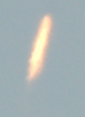 An unidentified object - thought to be North Korea's rocket launch - is photographed from Dandong, China, on Sunday.