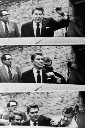 President Ronald Reagan waves, then looks up before being shoved into the presidential limousine by Secret Service agents after being shot outside a Washington hotel on March 30, 1981. 