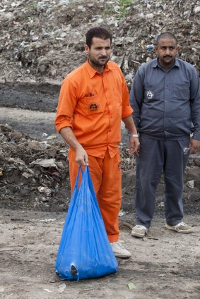 A Pakistani municipal worker carries a bag with dead rats to bury in the main garbage dump in Peshawar. 
