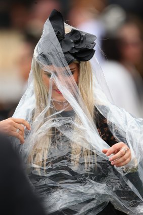 A spectator puts on a plastic rain cover during Derby Day at Flemington last year.