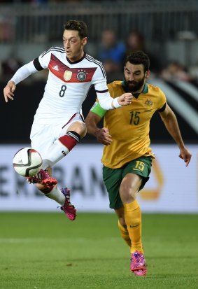 Mesut Oezil of Germany controls the ball as Mile Jedinak of Australia closes in.