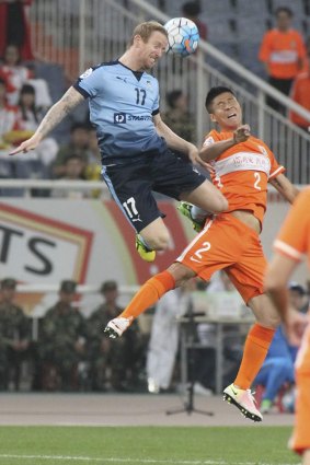 Flying high: David Carney and Zhao Mingjian of Shandong Luneng compete for the ball on Wednesday night.