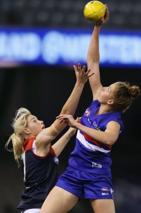 Emma King of the Bulldogs wins the tap over Tayla Harris of the Demons during an exhibition match in season 2015.