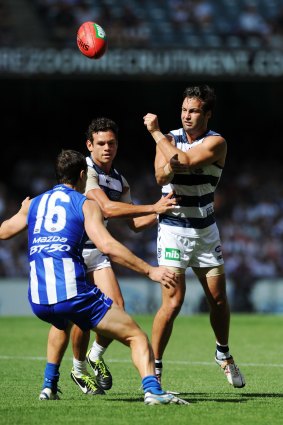 The Cats' Jimmy Bartel handballs during the round two match against North Melbourne in 2013.
