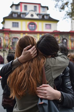 Two girls embrace opposite the main entrance of the Bataclan concert hall as French police lift the cordon.