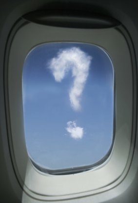 Airplane window with cloud in shape of question mark , (composite)