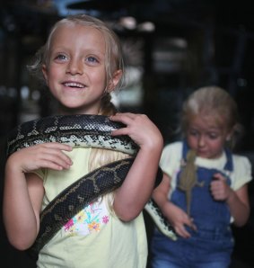 Immogen holds a carpet python and Lucy has a bearded dragon.