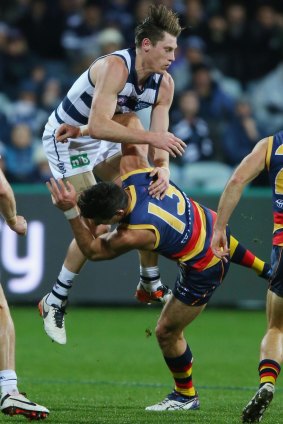 Geelong’s  Mark Blicavs collides with Adelaide’s Taylor Walker on Saturday night. 