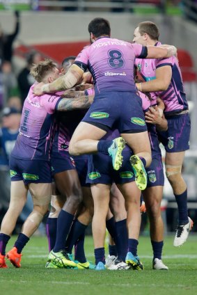 Ultimate player: Storm captain Cameron Smith is swamped by teammates after scoring the golden point winner against South Sydney on Saturday night. 
