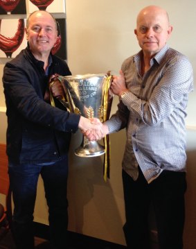 Hawks groupies: Hawthorn supporters Ross Stevenson and Sly of the Underworld shake hands holding a premiership cup they didn't win.