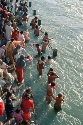 Hindu pilgrims at Kumbh Mela take a ritual bath in the Ganges River.