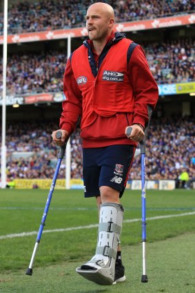 Nathan Jones leaves the ground on crutches after copping a head knock when competing for the ball against Dockers defender Zac Dawson.