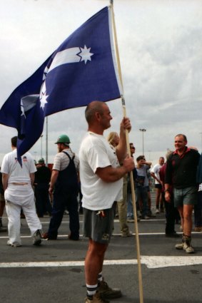 A man holds a Southern Cross flag at a rally at Webb Dock, Melbourne. April 8, 1998