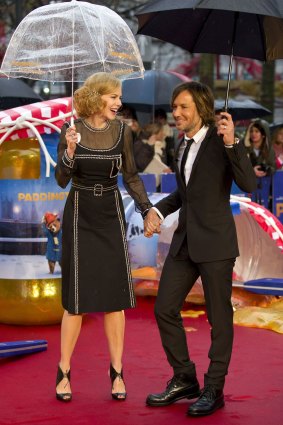 Under cover: Nicole Kidman and Keith Urban on the rain-drenched red carpet in London on Sunday.