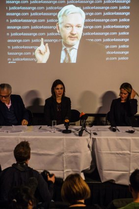 A panel of WikiLeaks representitives sit in front of Julian Assange as he speaks to the press.