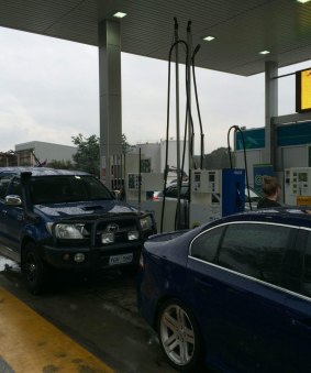 Customers queue for free fuel at Metro petrol station in Fyshwick at noon.