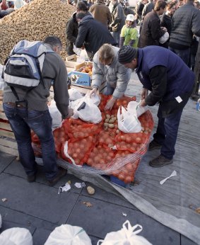 Country comes to town: Farmers from the French farmers unions distribute potatoes and fruits to residents after dumping 50 tons of fruit and vegetables during a protest in Place de La Republique.