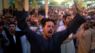 Coptic Christians shout slogans during a funeral service for victims of a bus attack, at Abu Garnous Cathedral in Minya, Egypt.