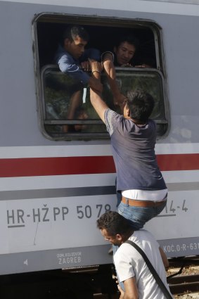 Migrants try to board a train in Tovarnik, Croatia.