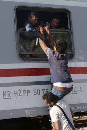 Migrants try to board a train in Tovarnik, Croatia.