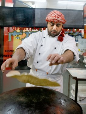Malek Nasser prepares a Malek a Saj - a type of soft stuffed pita roll.