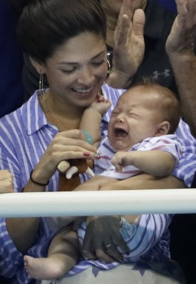 Phelps' fiancee, Nicole Johnson, with their son Boomer in the stands.