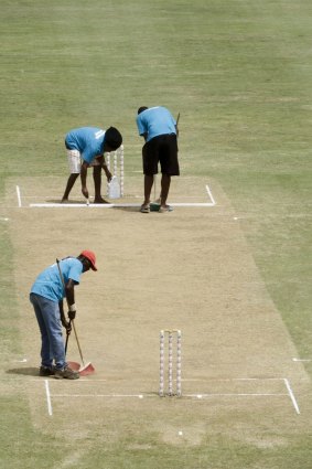 Groundstaff at Windsor Park attend to the pitch during a break on day three of the first Test between the West Indies and Australia in Dominica.