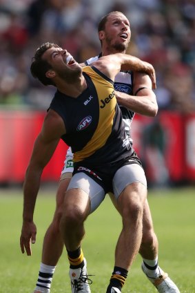 Alex Rance of the Tigers and James Kelly of the Cats compete for the ball.