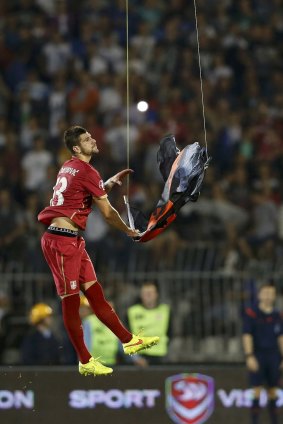 Serbia's Stefan Mitrovic grabs an Albanian flag that was flown over the pitch.