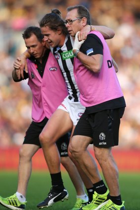 Tom Langdon is assisted from the field with an ankle injury during the match against the Eagles.