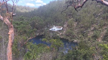A helicopter winches a 16-year-old boy to safety after he collapsed on a beach at the Georges River.