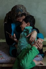 Threats to hold her son Assadullah - seen here in his mother's embrace - forced Basma to flee Tel Abyad in February 2014.