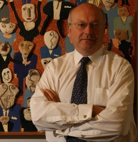 Federal Arts Minister George Brandis in the entrance to his Parliamentary offices in Canberra with an artwork called the Conference Party.