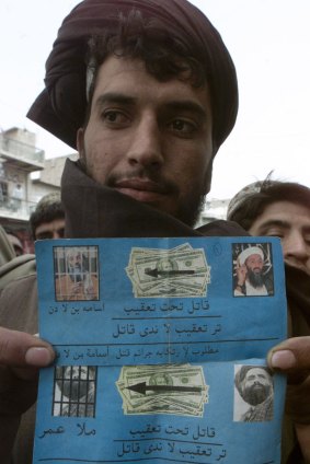 March 2003: A man living on the border between Pakistan and Afghanistan shows leaflets dropped by US  planes showing photos of Osama bin Laden and a man thought to be Taliban leader Mullah Mohammad Omar.